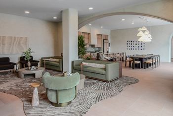 A living room with a green sofa and a patterned rug.